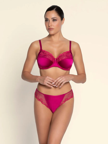 Woman wearing a pink bra and panties set on a beige background