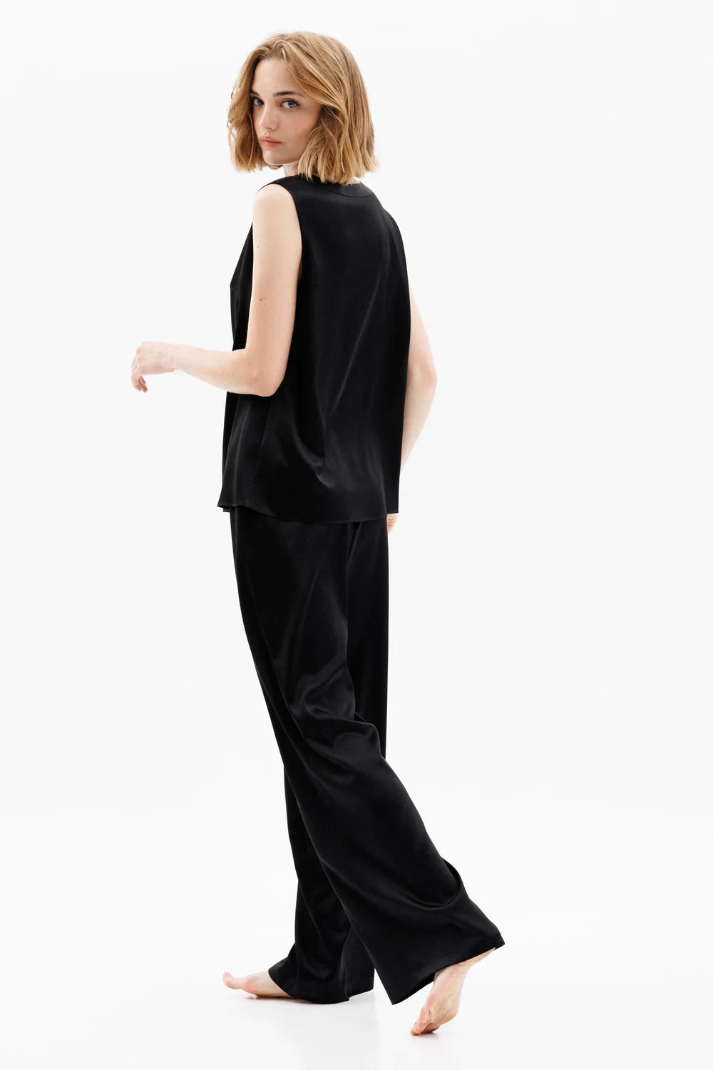 Woman wearing a black silk sleeveless top and black silk pants (sold separately) showing the back full look