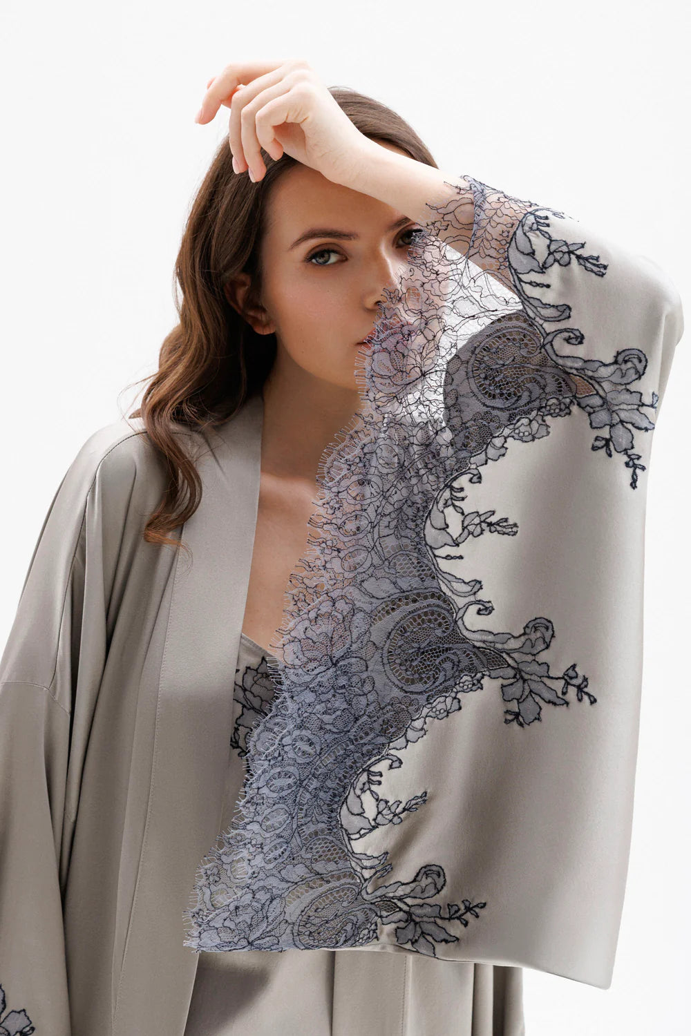 Woman wearing a gray silk robe with Leavers Lace sleeves showing the elegance of the sleaves and beauty of the anthracite lace