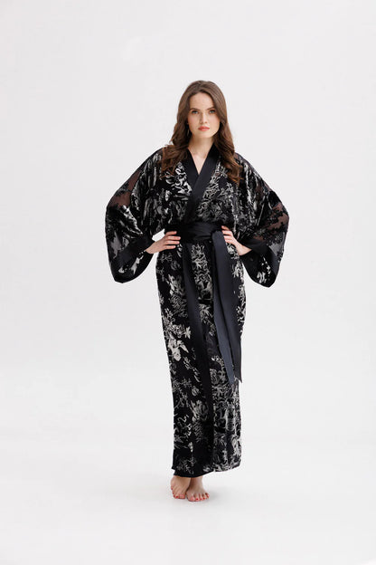 Woman wearing a black floral silk velvet kimono with wide belt. Front picture
